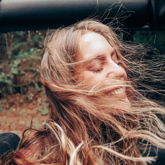 Image of Candace in a Jeep Wrangler on the Dragonstail in Tennessee with hair blown in her face.
